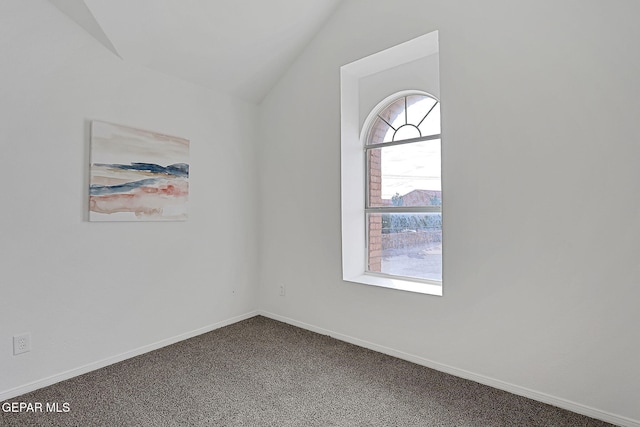 carpeted spare room with lofted ceiling