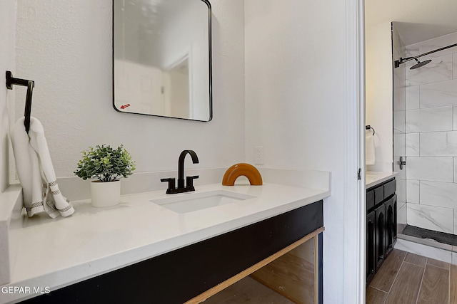 bathroom with vanity and tiled shower