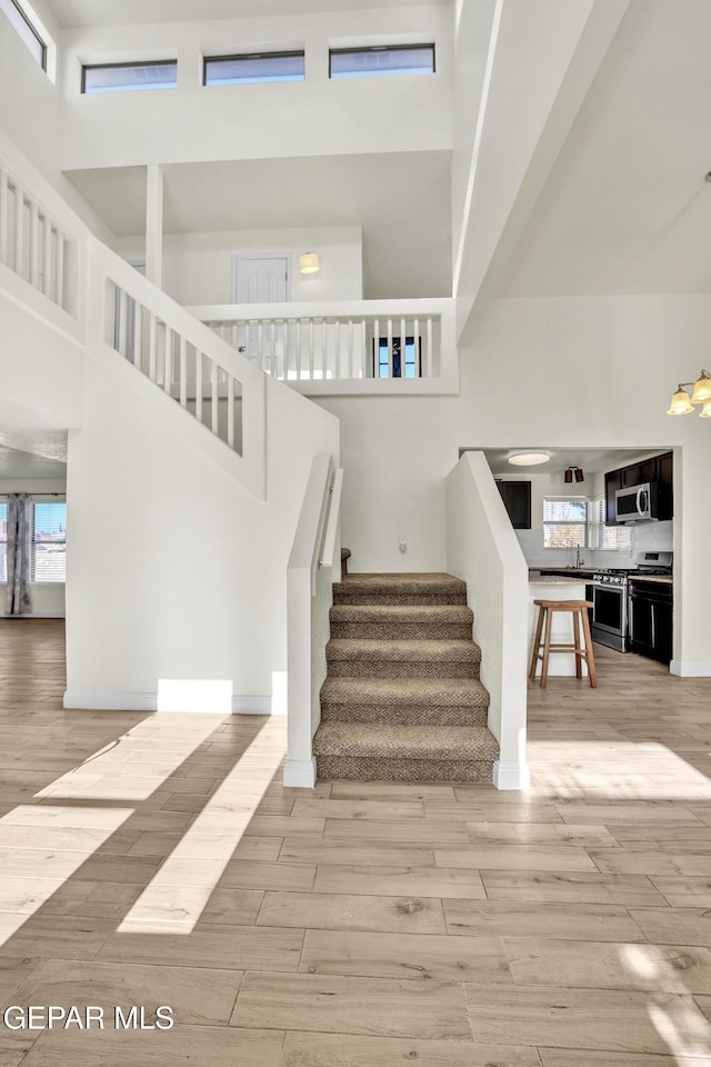 staircase featuring sink and a high ceiling