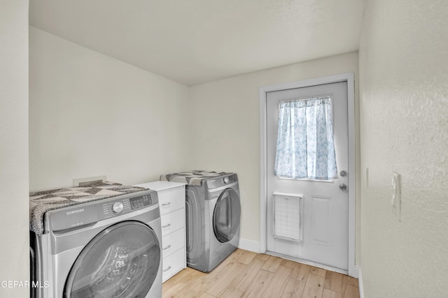 laundry room with separate washer and dryer and light hardwood / wood-style floors