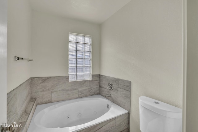 bathroom with toilet and tiled tub