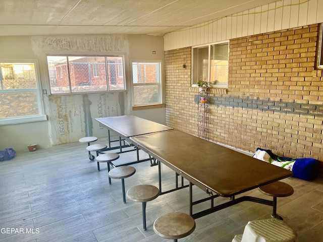 dining space featuring brick wall