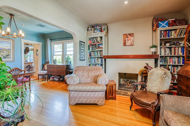 living area with a notable chandelier and light wood-type flooring