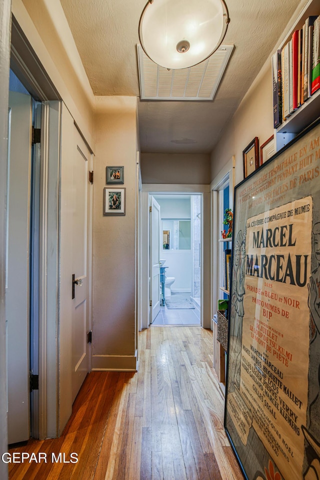 hall featuring hardwood / wood-style floors and a textured ceiling