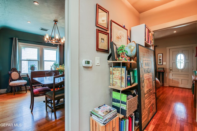 hallway featuring dark hardwood / wood-style flooring and a chandelier