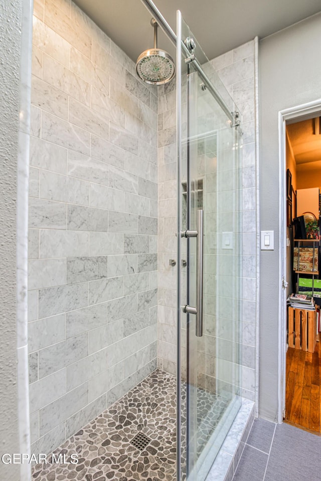 bathroom with tile patterned flooring and a shower with shower door