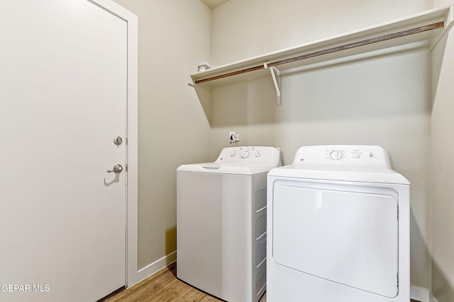 washroom with separate washer and dryer and light wood-type flooring