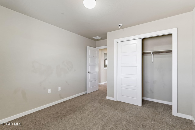 unfurnished bedroom with dark carpet and a closet