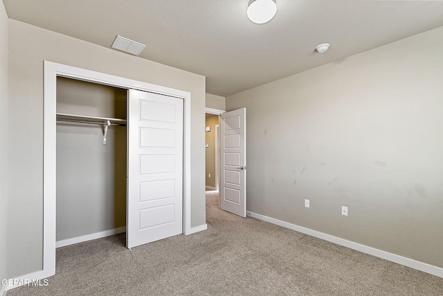 unfurnished bedroom featuring carpet and a closet