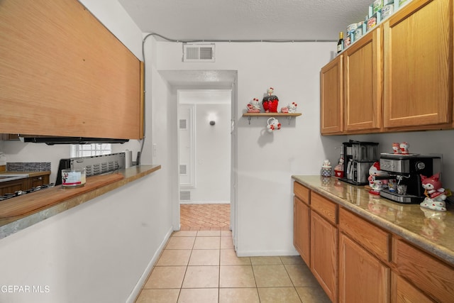 kitchen featuring a textured ceiling and light tile patterned flooring