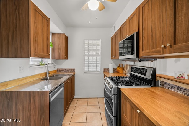 kitchen with sink, light tile patterned floors, ceiling fan, and appliances with stainless steel finishes