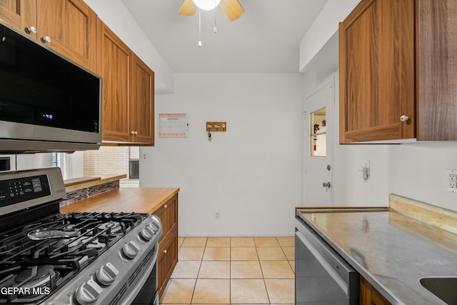 kitchen with light tile patterned flooring, appliances with stainless steel finishes, and ceiling fan