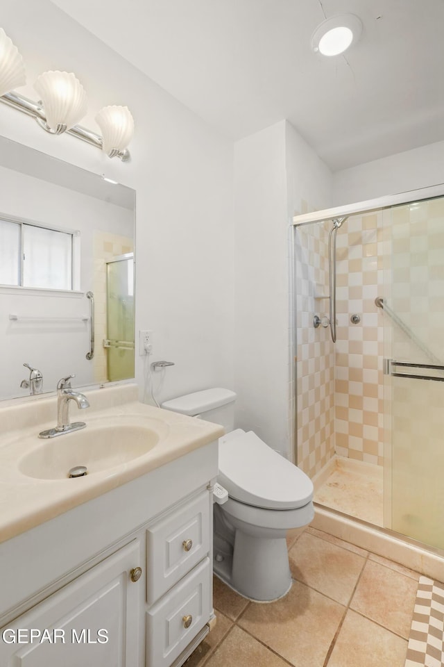 bathroom featuring tile patterned flooring, vanity, a shower with door, and toilet