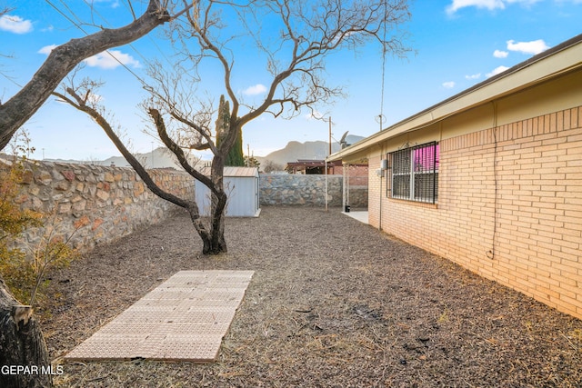 view of yard with a mountain view and a storage unit