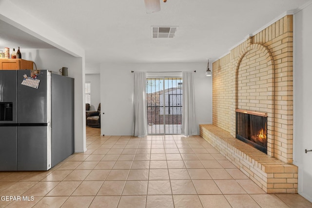 unfurnished living room with light tile patterned floors and a fireplace