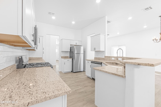 kitchen with white cabinetry, tasteful backsplash, kitchen peninsula, stainless steel appliances, and light hardwood / wood-style floors