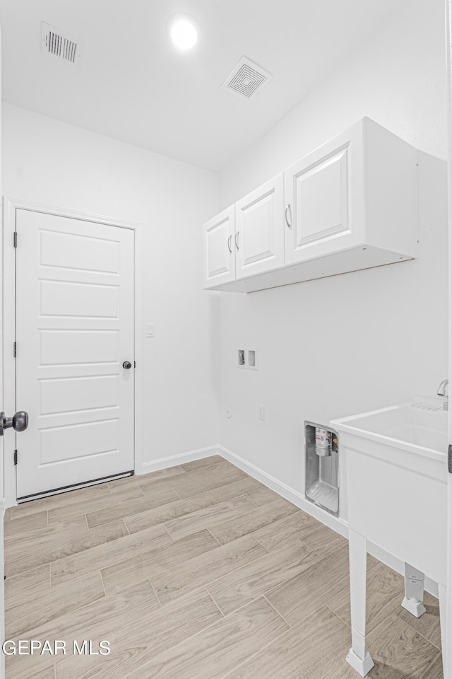 laundry area featuring hookup for a washing machine and cabinets