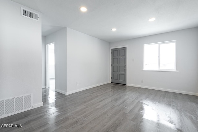 unfurnished room with baseboards, visible vents, wood finished floors, and recessed lighting