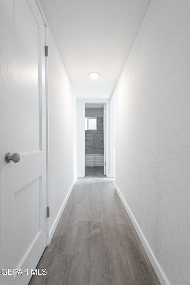 hall with wood finished floors and baseboards