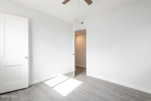 unfurnished bedroom with a ceiling fan, baseboards, visible vents, and wood finished floors