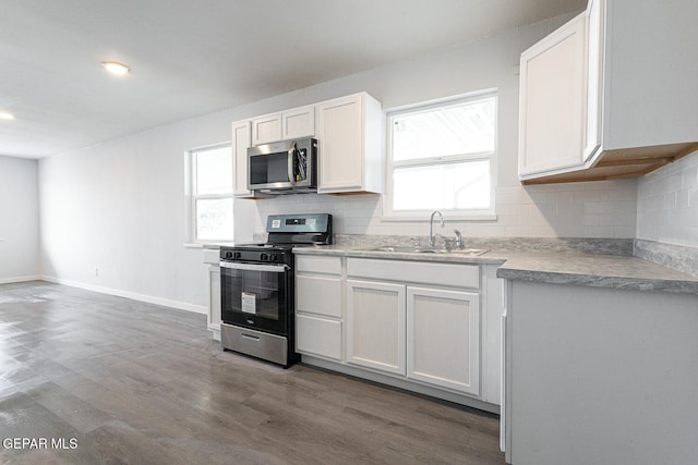 kitchen with plenty of natural light, stainless steel microwave, a sink, and gas stove