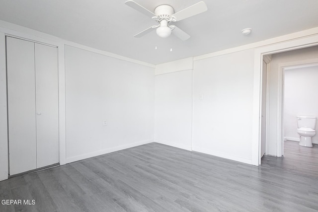 unfurnished bedroom with ceiling fan, wood finished floors, and baseboards