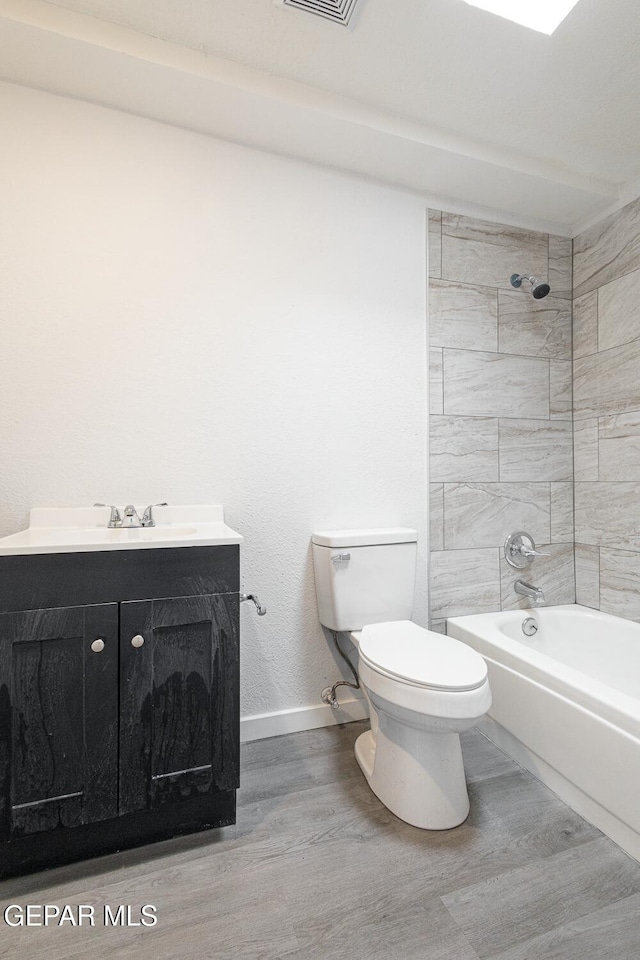 full bathroom featuring bathtub / shower combination, toilet, vanity, wood finished floors, and baseboards