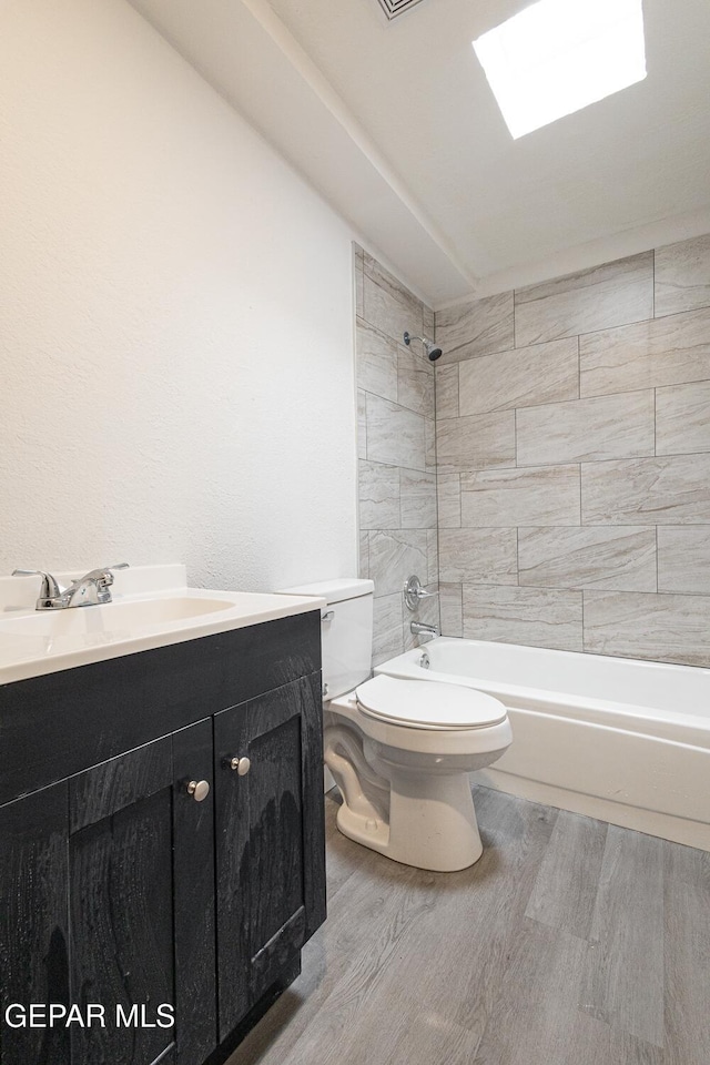 bathroom featuring bathtub / shower combination, vanity, toilet, and wood finished floors