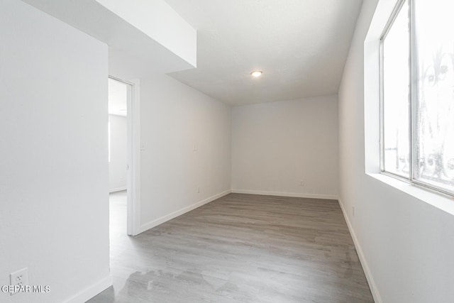 spare room featuring wood finished floors and baseboards