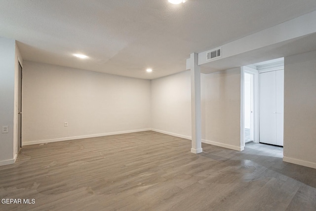 finished below grade area with baseboards, visible vents, wood finished floors, and recessed lighting