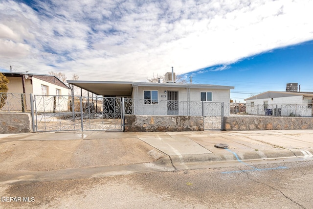 view of front of home with a fenced front yard, a gate, and an attached carport