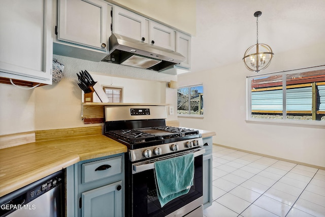 kitchen featuring pendant lighting, appliances with stainless steel finishes, a chandelier, and light tile patterned floors