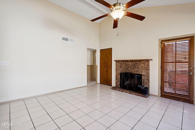 unfurnished living room with lofted ceiling, a fireplace, ceiling fan, and light tile patterned flooring