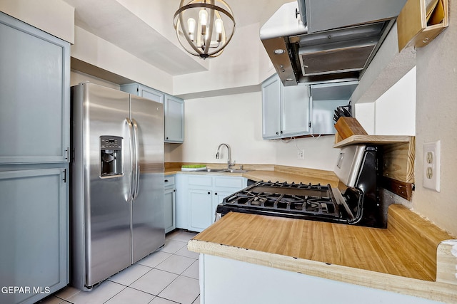 kitchen with sink, light tile patterned floors, gas range oven, stainless steel fridge with ice dispenser, and decorative light fixtures