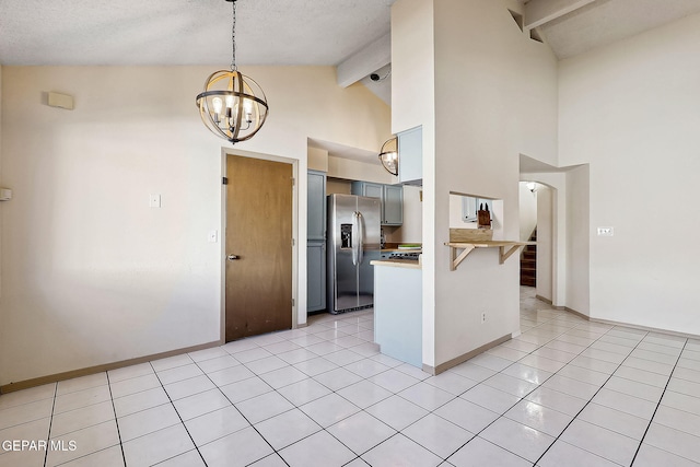 kitchen featuring a chandelier, light tile patterned floors, kitchen peninsula, stainless steel refrigerator with ice dispenser, and beam ceiling