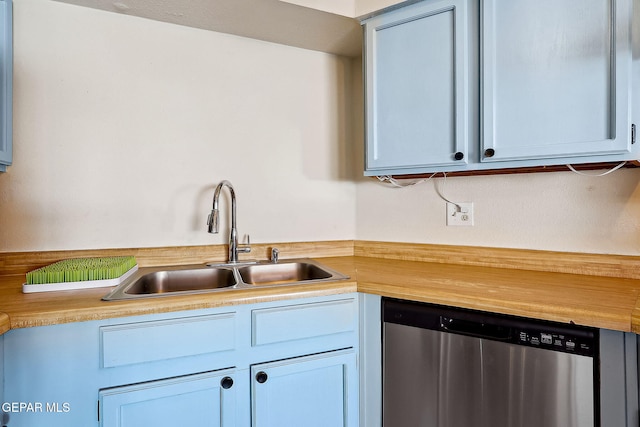 kitchen featuring stainless steel dishwasher, butcher block counters, and sink