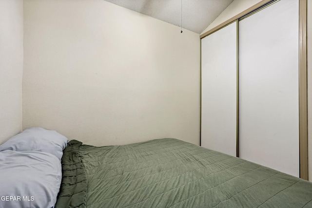 bedroom featuring vaulted ceiling and a closet