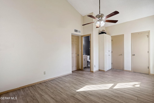 unfurnished bedroom with high vaulted ceiling, light hardwood / wood-style floors, ceiling fan, and ensuite bathroom