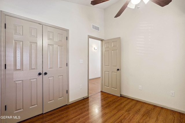 unfurnished bedroom featuring wood-type flooring, a closet, and ceiling fan