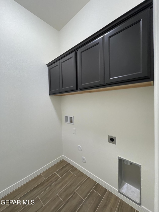 washroom featuring wood finish floors, washer hookup, gas dryer hookup, cabinet space, and hookup for an electric dryer