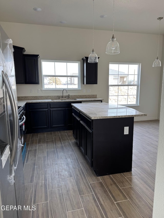 kitchen featuring dark cabinets, appliances with stainless steel finishes, and a sink