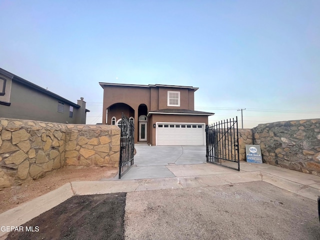 traditional home with an attached garage, fence, stucco siding, driveway, and a gate