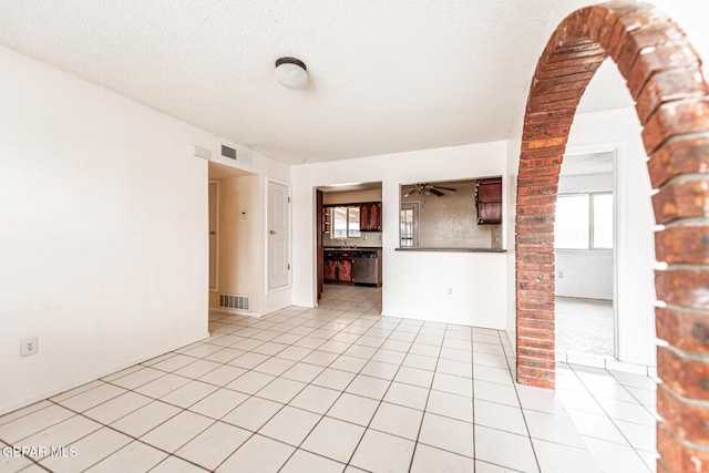 spare room featuring sink, ornate columns, a textured ceiling, light tile patterned floors, and ceiling fan