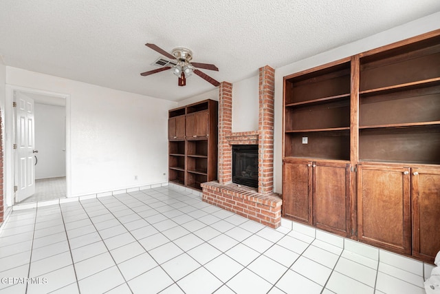 unfurnished living room featuring light tile patterned floors, a fireplace, built in features, and a textured ceiling