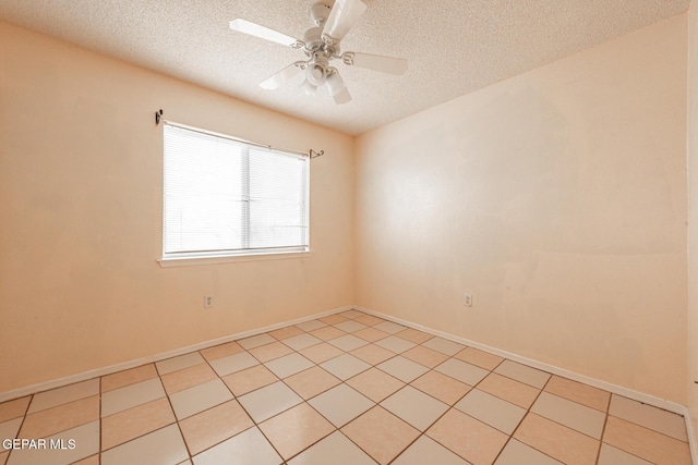 spare room featuring ceiling fan, a textured ceiling, and light tile patterned floors