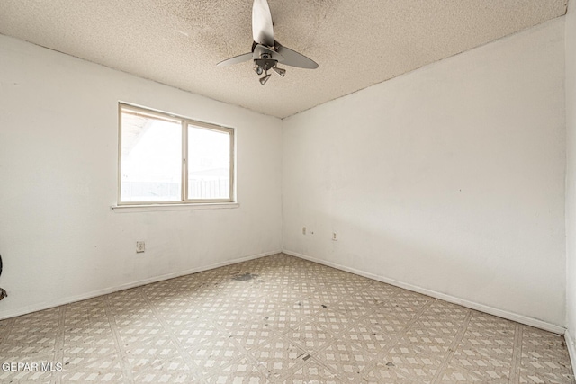 empty room with ceiling fan and a textured ceiling