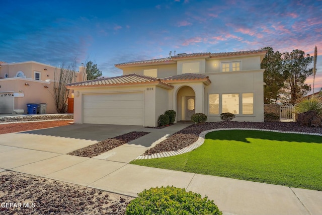 mediterranean / spanish-style house featuring a garage and a lawn