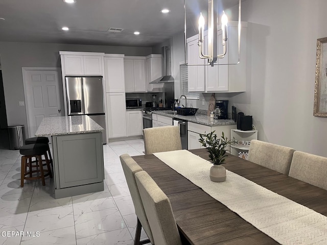 kitchen with decorative light fixtures, white cabinetry, a center island, stainless steel fridge with ice dispenser, and wall chimney exhaust hood