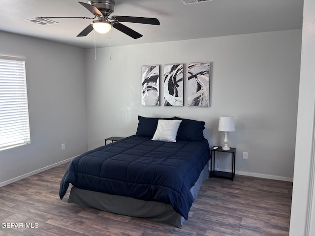 bedroom featuring ceiling fan, dark hardwood / wood-style flooring, and multiple windows