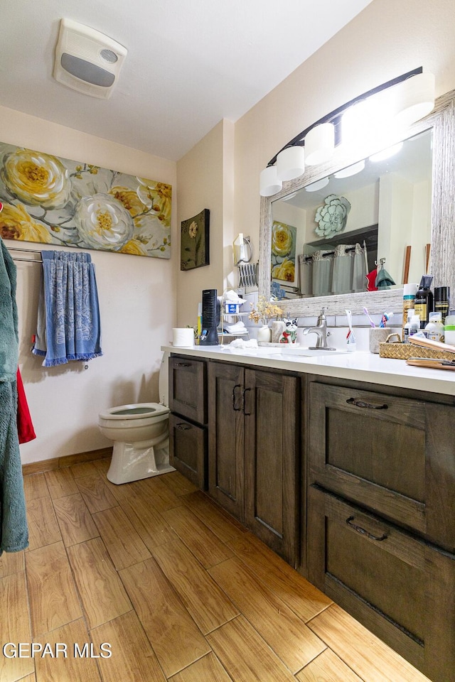 bathroom with vanity, hardwood / wood-style flooring, and toilet